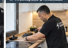 Arbeiten an Arbeitsplatte und Anschlüssen einer weißen Einbauküche